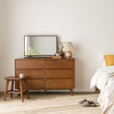 Nova Retro 6 Drawer Cabinet in wood finish with mirror lamp and decor in modern bedroom setting