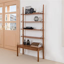 Wooden shelf by Born in Colour with multiple tiers holding books, decorative items, and a clock