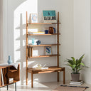Wooden shelf with four tiers displaying books and decorative items in a sunlit modern room